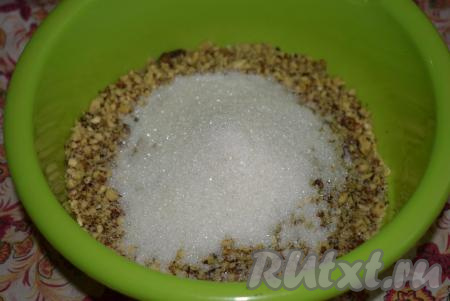 В миску высыпаем орехи. Добавляем к орехам сахар и перемешиваем.