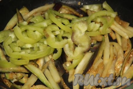 В сковороду влить растительное масло и поставить на огонь, затем выложить баклажаны и обжарить их на среднем огне в течение 5 минут, иногда помешивая. К обжаренным баклажанам добавить болгарский перец.&nbsp;