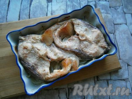 Запечь рыбу под майонезом с луком в разогретой духовке при температуре 180 градусов в течение 25-30 минут.