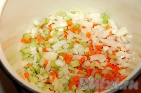 В кастрюлю влить оливковое масло и обжарить в нем нарезанные лук, морковь, сельдерей, очищенный и мелко нарезанный чеснок.