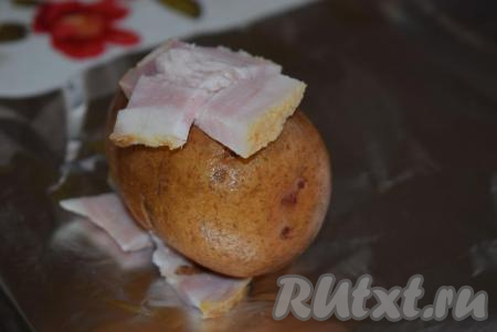 Переворачиваем клубень и на второй крестообразный надрез кладём 2 кусочка сала.