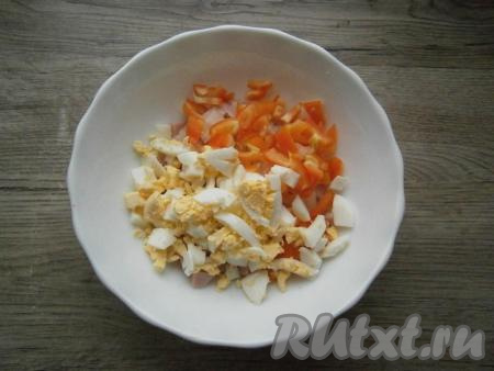 Перец болгарский нарезать небольшими квадратиками, яйца порубить. Яйца и болгарский перец добавить в салат из лука и ветчины.