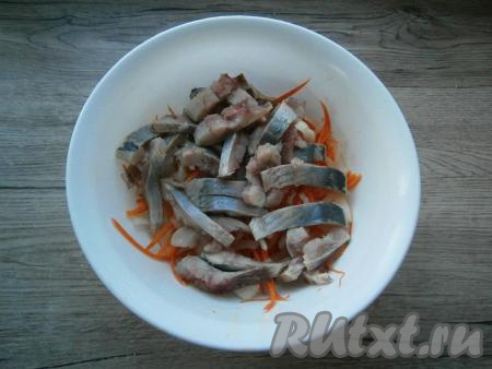 К морковке и луку добавить кусочки филе сельди.