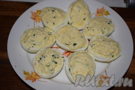 Чайной ложкой наполняем половинки яиц приготовленной начинкой.
