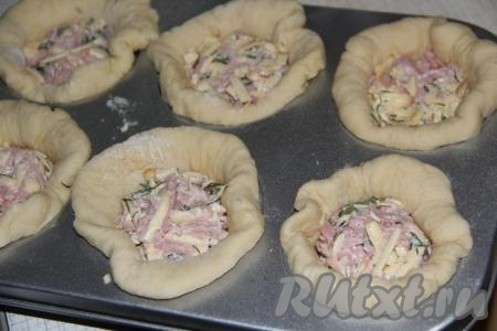 Форму для выпекания кексов смазать растительным или сливочным маслом. Выложить тесто в формы для кексов так, чтобы края теста были выше краёв формы. Внутрь выложить по 2 чайные ложки&nbsp;начинки. Оставить пирожки в формах на 30 минут.