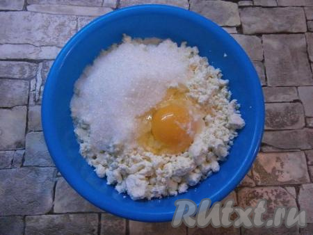 Сухофрукты, если будете добавлять, (у меня курага и изюм) залить кипятком и оставить на 5 минут, затем обсушить. В домашний творог добавить сырое яйцо, всыпать соль и сахар.
