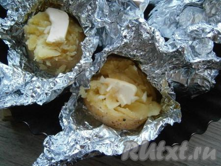 Запекать картофель в разогретой духовке&nbsp;около 45-60 минут при температуре 190 градусов (проверить готовность,&nbsp;проколов&nbsp;вилкой или ножом, - готовая картошечка будет легко прокалываться). Затем&nbsp;верх фольги развернуть, сделать на каждой картошине разрез и немного размять его сверху чайной ложкой. В&nbsp;разрез выложить по кусочку сливочного масла, измельченный чеснок и чуть посолить.