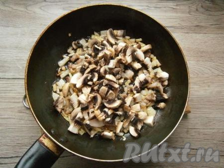 Шампиньоны очистить, нарезать на кусочки и выложить на сковороду с луком, влить немного растительного масла, посолить и поперчить.