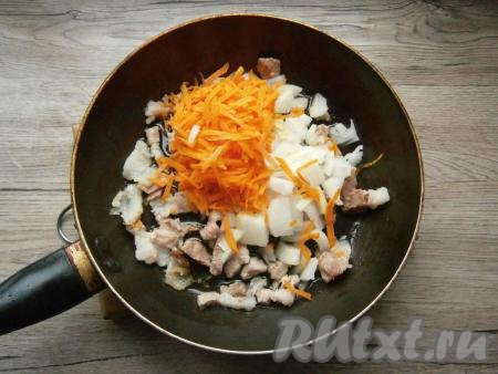 На сковороду с грудинкой (или на сухую сковороду, если готовите без грудинки) влить растительное масло, добавить нарезанный произвольно репчатый лук и натертую на крупной терке морковь.