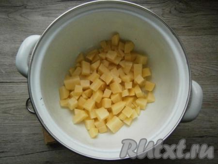 Картофель очистить и нарезать в кастрюлю небольшими кубиками.