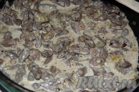 Перемешать потроха и влить сливки. Убавить огонь до минимума и томить пару минут.