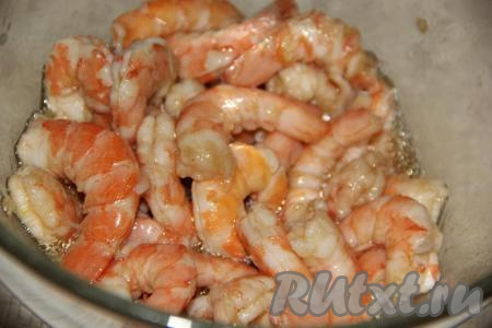 Креветки разморозить при комнатной температуре, затем очистить от голов и панцирей. Промыть креветки в холодной воде. Креветки замариновать в лимонном соке, пропущенном через пресс чесноке и масле. Оставить креветки в маринаде на 30 минут.