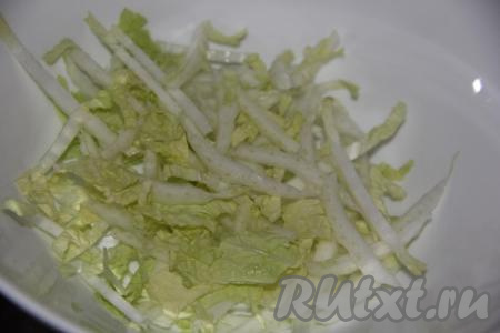 В глубокий салатник выложить нашинкованную пекинскую капусту.