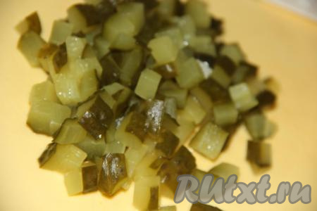 Соленые огурцы нарезать на кубики и добавить в кастрюлю. Варить рассольник с булгуром еще 5 минут.