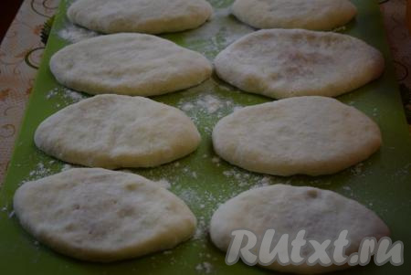 Досочку присыпаем мукой и выкладываем подготовленные пирожки швом вниз, слегка приплющивая их рукой. Даем пирожкам с картошкой и луком немного подойти (в течение минут 15), накрыв их полотенчиком.