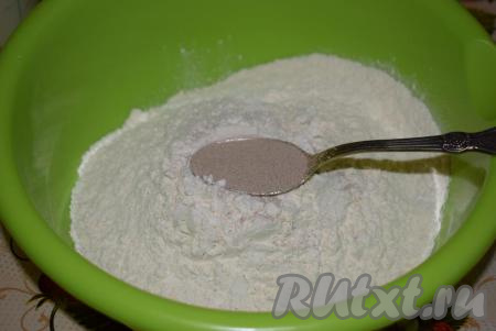 В глубокую миску выкладываем просеянную муку и сухие дрожжи, тщательно перемешиваем.