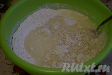 В смесь муки и дрожжей выливаем жидкую смесь и начинаем замешивать тесто при помощи ложки.