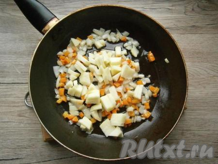 Обжарить лук с морковью на среднем огне 2-3 минуты, далее добавить очищенное от семян и кожуры и нарезанное кубиками кислое яблоко, обжарить все вместе еще 2-3 минуты, помешивая.