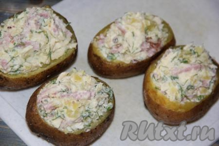 Выложить начинку в картофельные лодочки.