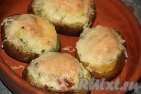 Картошку, фаршированную ветчиной и сыром, запекать в разогретой духовке при температуре 200 градусов, примерно, 15-20 минут.