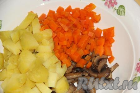 Варёную морковь очистить, нарезать кубиками и выложить в салат из картошки и шампиньонов.