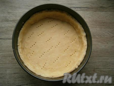Большую часть теста раскатать и выложить ее в разъемную форму диаметром 18-20 см, формируя бортики. Тесто наколоть вилкой.