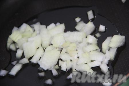 В сковороду добавить 1 столовую ложку растительного масла, выложить мелко нарезанный лук.