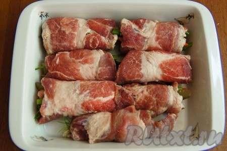 Свиные рулетики с начинкой укладываем в огнеупорную посуду, швом вниз. По желанию можно смазать сметаной. Накрываем фольгой, отправляем в разогретую духовку до 180-200 градусов на 30-40 минут.