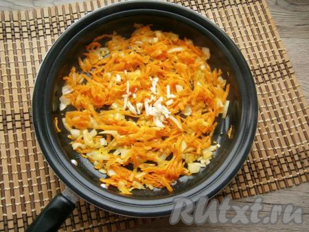 Обжарить морковку с луком, помешивая, до мягкости на среднем огне, затем добавить мелко нарезанный чеснок, перемешать.