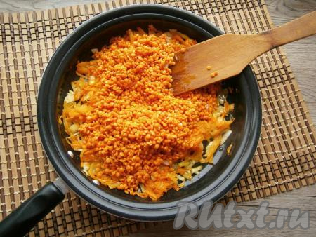 Промытую чечевицу высыпать в сковороду к обжаренным овощам.