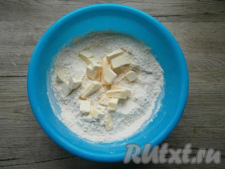 Холодное сливочное масло нарезать небольшими кусочками, добавить его в мучную смесь.