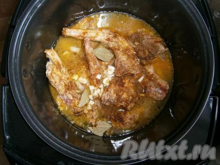 Затем влить в чашу горячую воду, всыпать еще немного специй и соль, добавить нарезанный чеснок и лавровые листья.