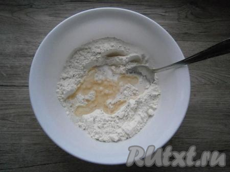 Влить растительное масло и немного теплого молока. Ложкой смешать молоко и масло&nbsp;с частью муки.