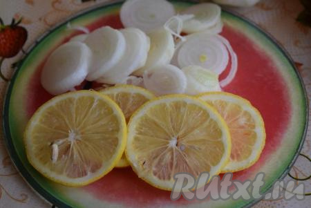 Репчатый лук очистим от кожуры и нарежем на тонкие кольца. Половину лимона нарежем на дольки. Из второй половины лимона нужно выжать сок прямо в миску с мясом.