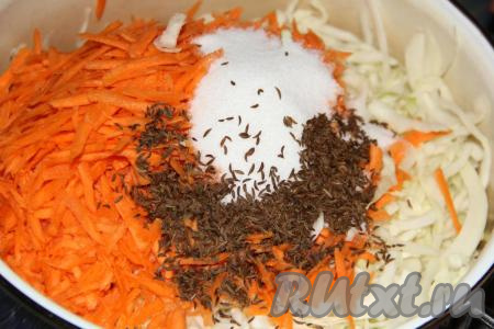 Морковь очистить и натереть на крупной тёрке. Добавить натёртую морковь, соль и тмин в кастрюлю к капусте.