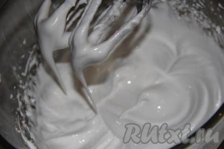 Затем в пышную яичную пену всыпать сахарную пудру, продолжая взбивать. Взбивайте глазурь на низкой скорости миксера, хотя на это и потребуется немного больше времени, чем на взбивание на высокой скорости. Глазурь станет гладкой и блестящей, при остановке миксера будут стойкие пики. В конце взбивания добавить лимонный сок и ещё немного взбить (секунд 30).