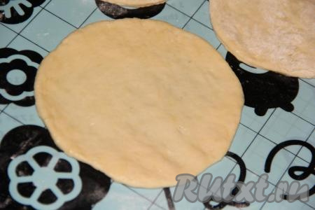 Затем разделить тесто на небольшие кусочки. Скалкой раскатать каждый кусочек теста в круг диаметром, примерно, 13-16 см. Смазать круг растительным маслом.