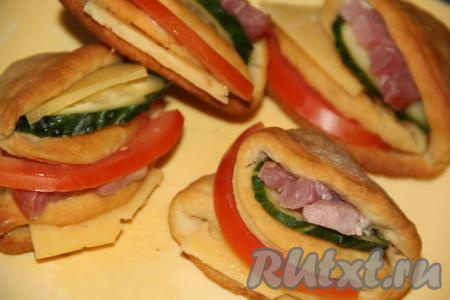 В получившиеся кармашки вложить начинку. По желанию, можно смазать кармашки кетчупом или майонезом - это легче всего сделать кулинарной силиконовой кисточкой.