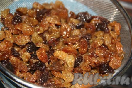 Затем откинуть запаренный изюм на дуршлаг.