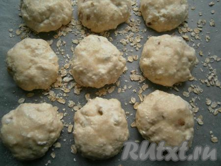 Мокрыми руками формировать&nbsp;шарики&nbsp;(размер выбирайте сами) и выкладывать их на противень, застеленный пергаментом и посыпанный овсяными хлопьями, на расстоянии друг от друга 3-4&nbsp;см. Сверху&nbsp;смазать теплым молоком и присыпать немного сахаром.