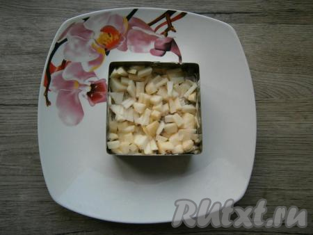 Немного смазать сельдь майонезом и выложить сверху слой предварительно очищенного от кожуры и семян, нарезанного маленькими кубиками яблока.