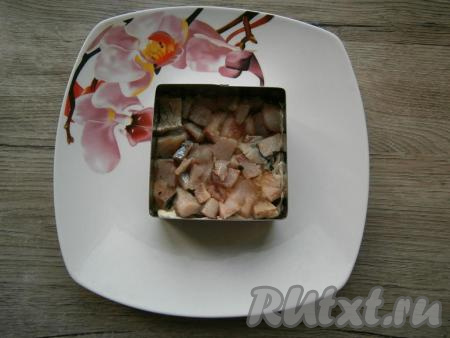 Следующим слоем выложить нарезанное кусочками филе селедки.