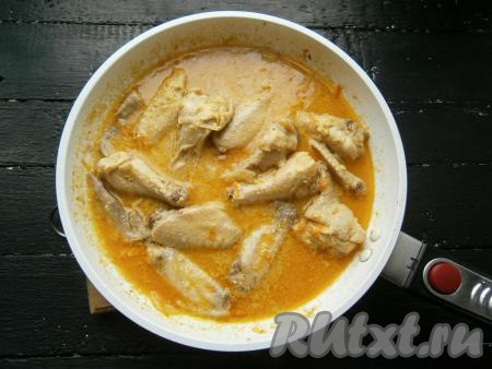 Довести все до кипения, огонь сделать минимальным, сковороду накрыть крышкой. Тушить куриные крылья в сметане около 35-40 минут. В конце добавить измельченный чеснок.