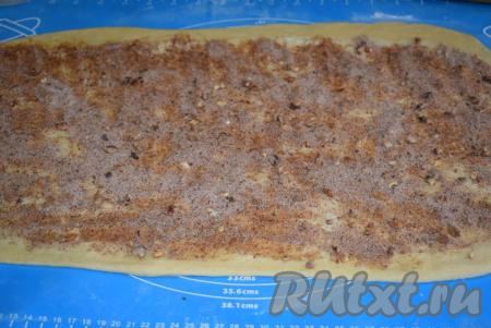 Смазываем пласт теста 25 граммами размягченного сливочного масла. Затем по всему периметру теста&nbsp;распределяем равномерно половину приготовленной начинки, оставляя по 2 см с краев чистыми.