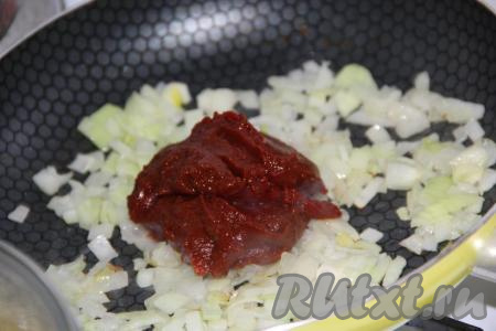 Через несколько минут с начала обжаривания лук станет прозрачным, выложить к нему томатную пасту, перемешать.