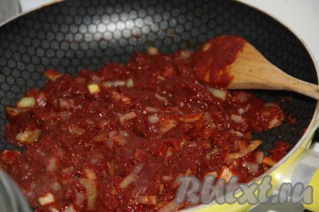 Лук с томатной пастой обжарить на среднем огне в течение 1-2 минут, периодически помешивая.