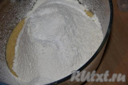 Сюда же добавить просеянную муку и разрыхлитель, хорошо перемешать тесто ложкой.