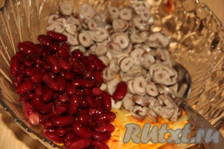 Затем в салат из куриных сердечек и овощей добавить фасоль и соль, перемешать.