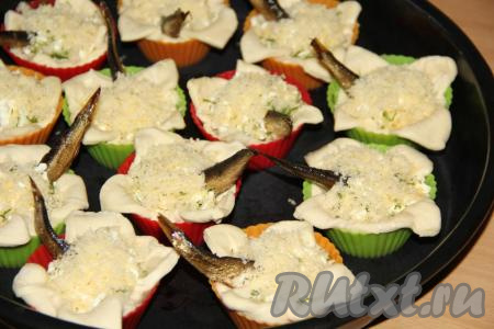 Поставить формы на противень и присыпать начинку всех слоек тёртым сыром.&nbsp;