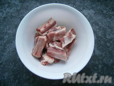 Ребрышки вымыть, обсушить и нарезать на части по кости.